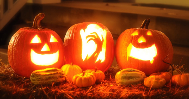 three carved and lit up Halloween pumpkins 